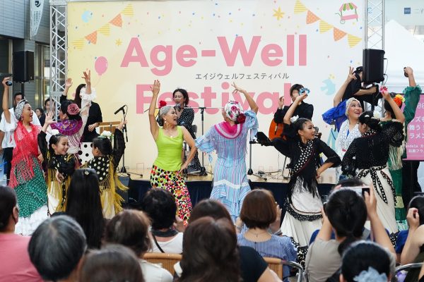 【イベントレポート】 超高齢社会をポジティブに楽しむ！シニアが輝く未来を体感する「Age-Well Festival 2025 」開催！ ～シニアとその家族向けのイベントや展示で16,000人以上が来場～ 株式会社AgeWellJapan 2025年9月9日 11時00分 2 フラメンコを披露する5歳〜80代が所属する「Candela カンデーラ 松 彩果フラメンコ教室」 孫世代の相棒サービス「もっとメイト」や多世代コミュニティスペース「モットバ！」を展開する株式会社AgeWellJapan（本社：東京都渋谷区、代表取締役社長：赤木円香、以下「AgeWellJapan」）は、2025年9月6日（土）、7日（日）に東京・二子玉川ライズガレリアで「Age-Well Festival 2025」を開催いたしました。本フェスティバルは「超高齢社会をポジティブにとらえる」ことをテーマに、最新の取り組みやサービス、そして世代を超えた対話を通じて“Age-Wellな社会づくりを目指すイベントです。2日間で16,000人以上が来場し、誰もが豊かに歳を重ねる社会に向けて多くの交流が行われました。 ◼︎Age-Well Festival開催レポート 豪華ゲストによるトークショー＆パフォーマンス ステージでは、子どもからシニアまで幅広い世代が楽しめるプログラムを実施しました。 初日には俳優の南野陽子さんが登壇し、山登りの魅力を語るトークショーを開催。シニアダンスチームFIDA JAPAN健康クラブによる迫力あるパフォーマンスや、日本最年長の新人アイドル myunとyayo～ さんの歌謡ショーも披露されました。 2日目は、TikTokフォロワー460万人を誇るおじゃすさんや、“天使の歌声”と話題の川合結人さんが登場し、会場を大いに盛り上げました。このほか、変身ショーやエクササイズ、情熱的なフラメンコなど、多彩なステージが繰り広げられ、2日間にわたり大きな盛況となりました。